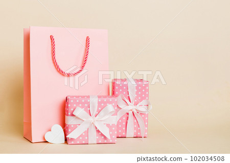 Shopping bag with gift box on colored background perspecrive view. Space for text holiday concept Shopping bag with gift box on colored background perspecrive view. Space for text holiday concept 102034508