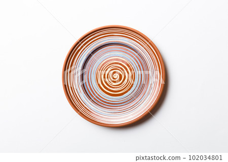 Top view of isolated of colored background empty round brown plate for food. Empty dish with space for your design 102034801