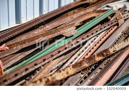Pile of rusted steel fence posts on the ground 102040009