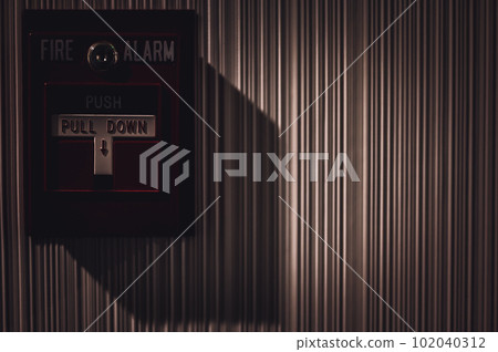 Selective focus on a wall mounted fire alarm switch in a empty hallway Selective focus on a wall mounted fire alarm switch in a empty hallway 102040312