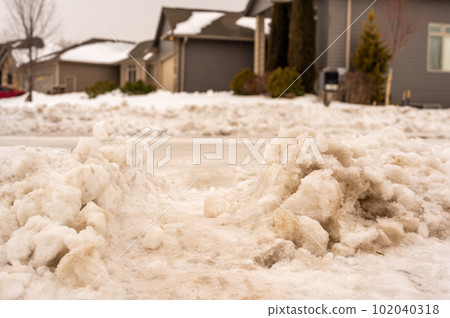 Snowbank at the end of a driveway left after city snowplows cleared a street. Snowbank at the end of a driveway left after city snowplows cleared a street. 102040318