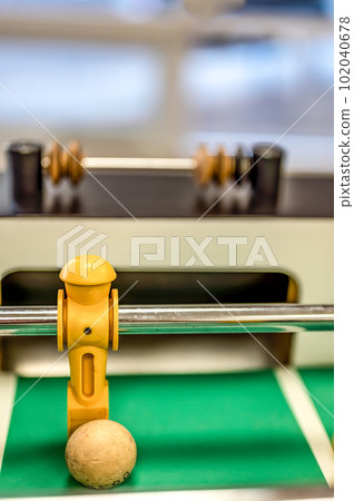 Selective focus on a foosball goalie blocking the ball insider the box. 102040678
