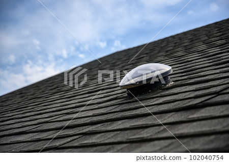 Dome shaped solar tube skylight on asphalt shingle roof  102040754