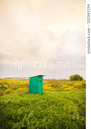 wooden toilet with a carved window in the shape of a heart, an open field wooden toilet with a carved window in the shape of a heart, an open field 102041554