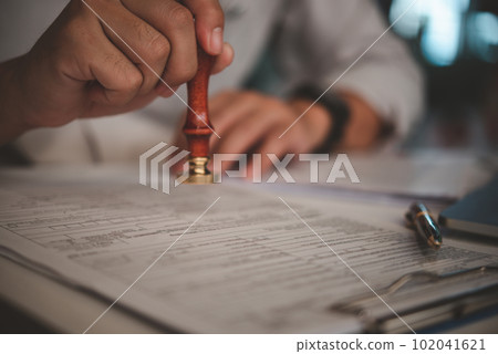 Man stamping approval of work finance banking or investment marketing documents on desk. Man stamping approval of work finance banking or investment marketing documents on desk. 102041621
