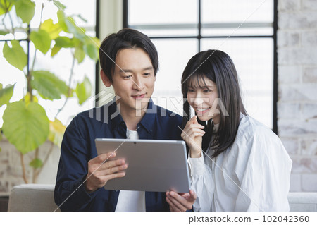 Girls watching tablets Girls watching tablets 102042360