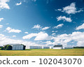 Steel barn on a farm with cloudy blue sky. 102043070