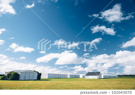 Steel barn on a farm with cloudy blue sky. Steel barn on a farm with cloudy blue sky. 102043070