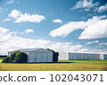 Steel barn on a farm with cloudy blue sky. 102043071