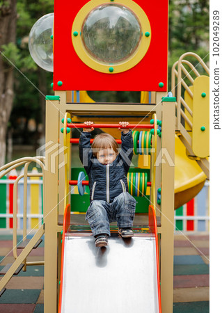 Little boy climbing on the playground. Kid play on kindergarten yard. 102049289