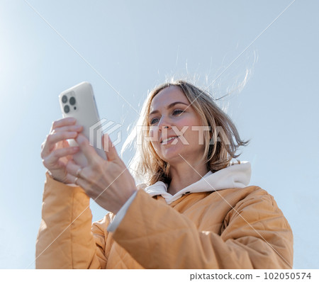 A beautiful young stylish woman walking in the city Spring mood dreaming and waiting a lifestyle concept A beautiful young stylish woman walking in the city Spring mood dreaming and waiting a lifestyle concept 102050574