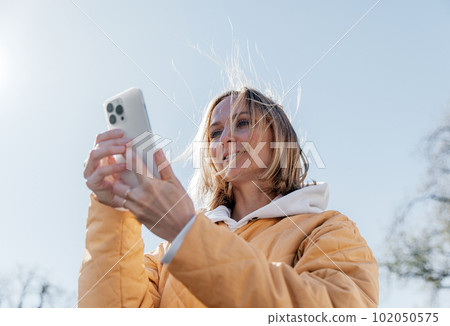 A beautiful young stylish woman walking in the city Spring mood dreaming and waiting a lifestyle concept A beautiful young stylish woman walking in the city Spring mood dreaming and waiting a lifestyle concept 102050575