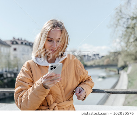 A beautiful young stylish woman walking in the city Spring mood dreaming and waiting a lifestyle concept A beautiful young stylish woman walking in the city Spring mood dreaming and waiting a lifestyle concept 102050576