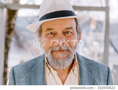 Portrait of a confident, handsome, mature man, pensioner, grandfather in the small town 102050622