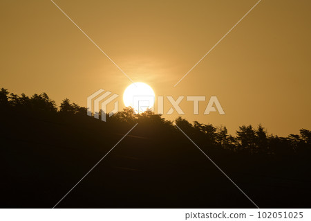 The sun rising in the reddish yellow sky in Hakushu Town, Hokuto City 102051025