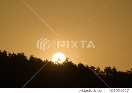 The sun rising in the reddish yellow sky in Hakushu Town, Hokuto City 102051027