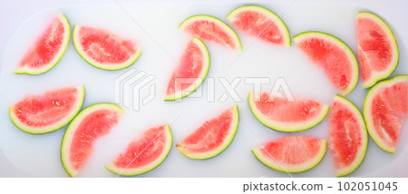 Turbid soapy water in bath with slices of watermelon. top view in full frame. The largest berry. spa with milk in the bath for rejuvenation.. Turbid soapy water in bath with slices of watermelon. top view in full frame. The largest berry. spa with milk in the bath for rejuvenation.. 102051045