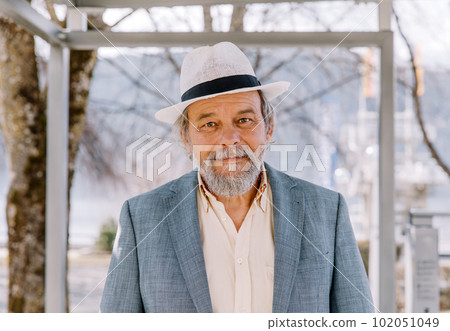 Portrait of a confident, handsome, mature man, pensioner, grandfather in the small town Portrait of a confident, handsome, mature man, pensioner, grandfather in the small town 102051049