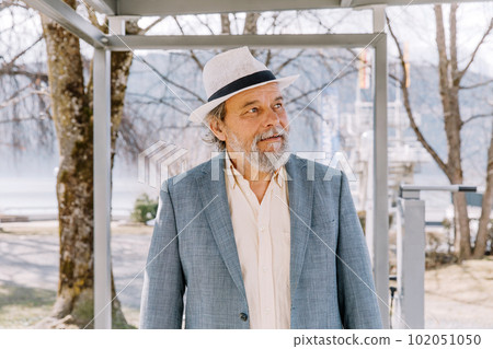 Portrait of a confident, handsome, mature man, pensioner, grandfather in the small town Portrait of a confident, handsome, mature man, pensioner, grandfather in the small town 102051050