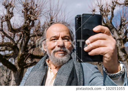 Portrait of a confident, handsome, mature man, pensioner, grandfather in the small town 102051055