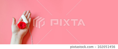 Womans hand holds hygienic cotton tampon. Concept of intimate hygiene and health. Copy space. Womans hand holds hygienic cotton tampon. Concept of intimate hygiene and health. Copy space. 102051456
