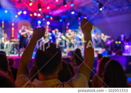 Dancing people enjoying live concert in illuminated club Dancing people enjoying live concert in illuminated club 102051553