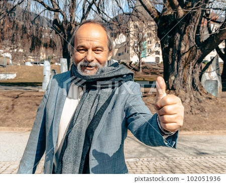 Portrait of a confident, handsome, mature man, pensioner, grandfather in the small town 102051936