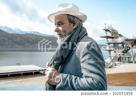 Portrait of a confident, handsome, mature man, pensioner, grandfather in the small town 102051956