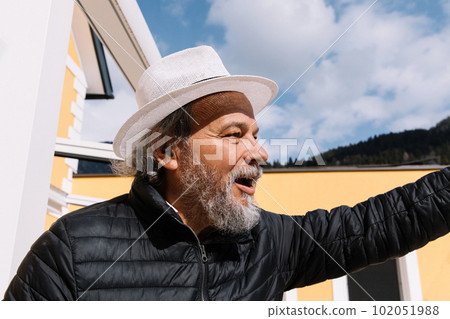 Portrait of a confident, handsome, mature man, pensioner, grandfather in the small town 102051988