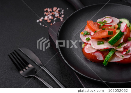 Delicious vegan salad of fresh vegetables of tomatoes, cucumbers and radishes Delicious vegan salad of fresh vegetables of tomatoes, cucumbers and radishes 102052062