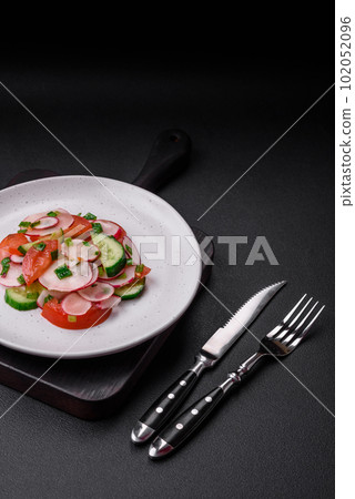Delicious vegan salad of fresh vegetables of tomatoes, cucumbers and radishes 102052096