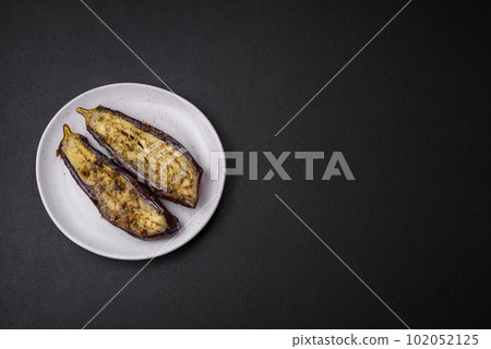 Delicious eggplant cut into two halves baked with salt, spices and herbs Delicious eggplant cut into two halves baked with salt, spices and herbs 102052125