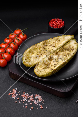 Delicious zucchini cut into two halves baked with salt, spices and herbs 102052136