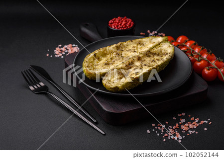 Delicious zucchini cut into two halves baked with salt, spices and herbs 102052144
