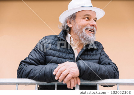 Portrait of a confident, handsome, mature man, pensioner, grandfather near his house, anti aging activities 102052308