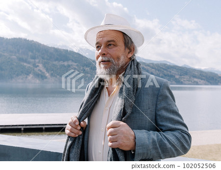 Portrait of a confident, handsome, mature man, pensioner, grandfather in the small town Portrait of a confident, handsome, mature man, pensioner, grandfather in the small town 102052506