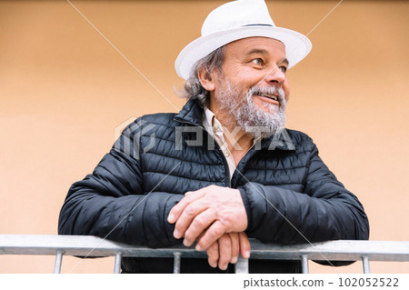 Portrait of a confident, handsome, mature man, pensioner, grandfather near his house, anti aging activities 102052522