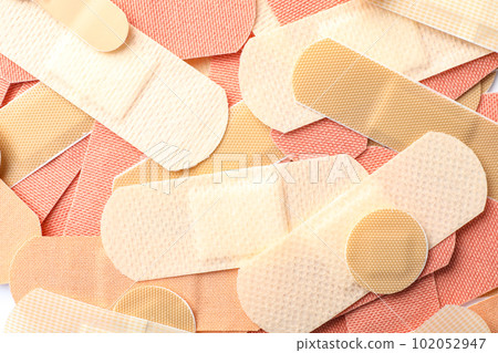 Different medical sticking plasters as background, closeup. First aid item Different medical sticking plasters as background, closeup. First aid item 102052947