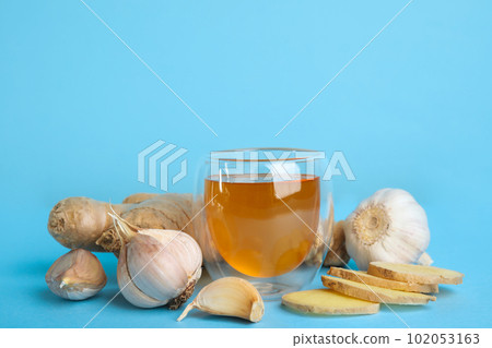 Fresh garlic and other natural cold remedies on light blue background. Space for text 102053163