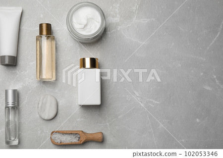 Flat lay composition with cosmetics on grey marble table, space for text. Spa treatment 102053346