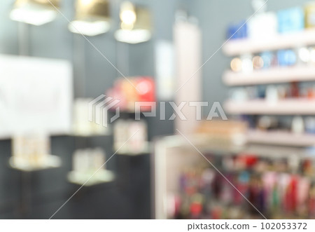Blurred view of counter and shelves with perfume bottles in shop Blurred view of counter and shelves with perfume bottles in shop 102053372