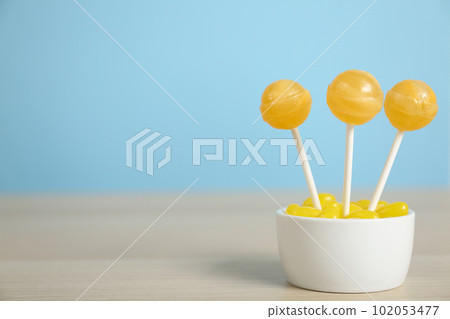 Different lemon candies on wooden table. Space for text Different lemon candies on wooden table. Space for text 102053477