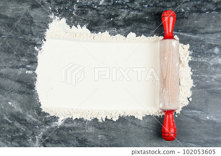 Flour and rolling pin on grey marble table, top view. Space for text Flour and rolling pin on grey marble table, top view. Space for text 102053605