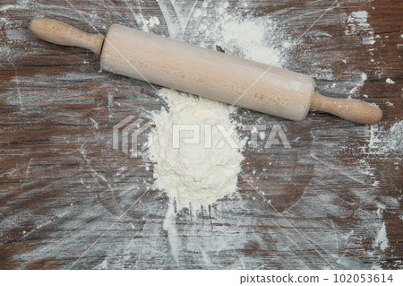 Flour and rolling pin on wooden table, top view Flour and rolling pin on wooden table, top view 102053614