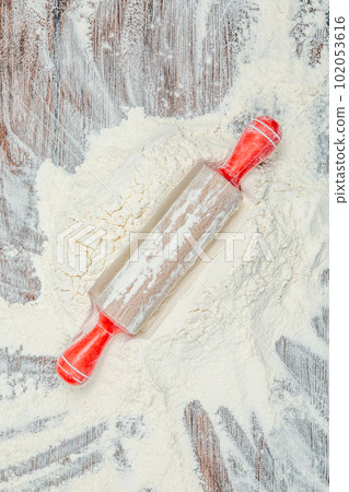 Flour and rolling pin on wooden table, top view 102053616