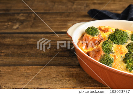 Tasty broccoli casserole in baking dish on wooden table. Space for text Tasty broccoli casserole in baking dish on wooden table. Space for text 102053787