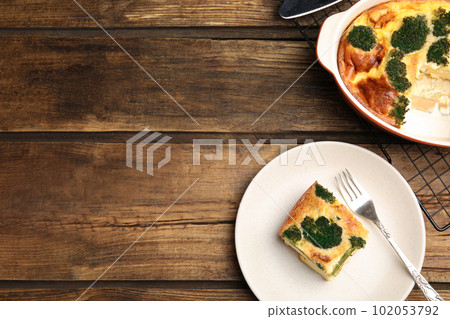 Tasty broccoli casserole served on wooden table, flat lay. Space for text 102053792