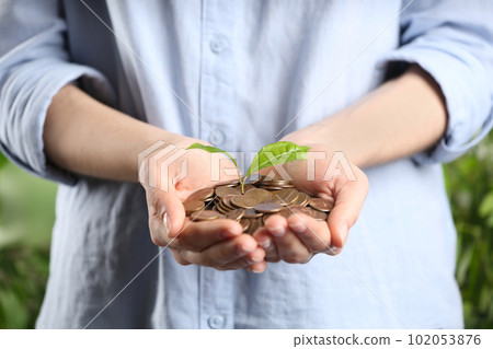 Woman holding coins and green sprout, closeup. Money savings Woman holding coins and green sprout, closeup. Money savings 102053876