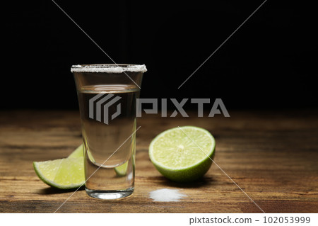 Mexican Tequila shot with salt and lime on wooden table. Space for text 102053999