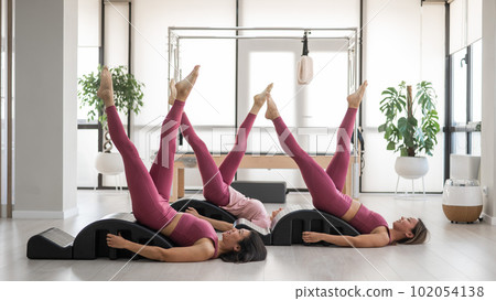 Balanced Body Pilates Arc. Three asian women exercising on pilates arc.  102054138